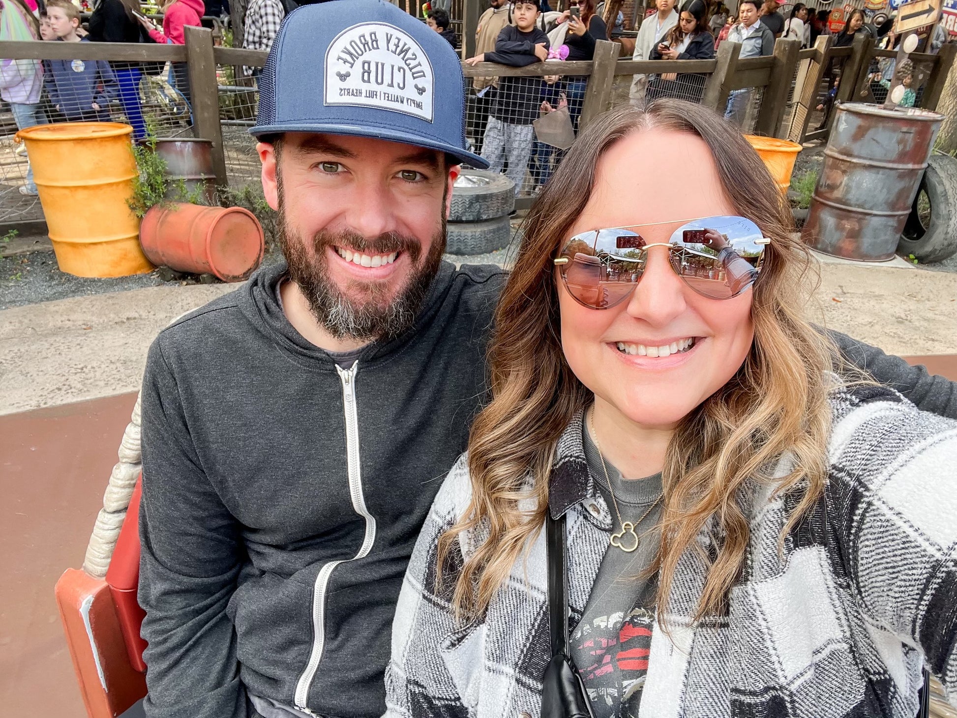 couple wearing disney broke club hat