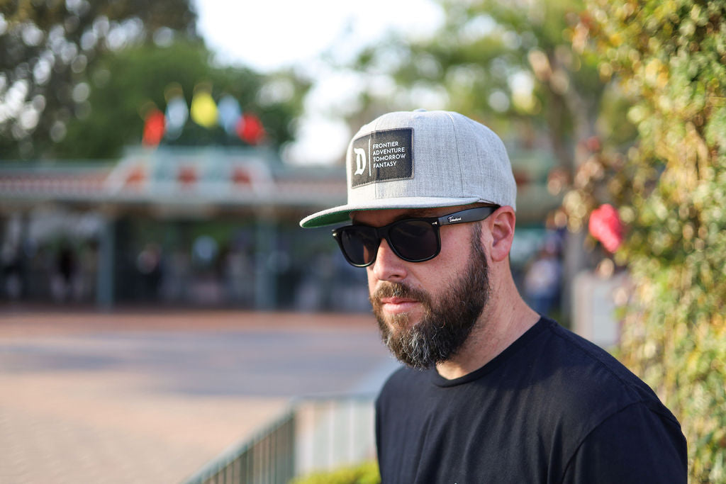 man in a disneyland 4-lands hat