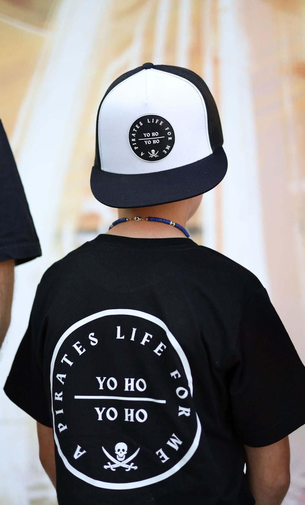 young kid hat backwards with pirates life patch